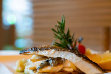 Beyaz balıklı fileto, limon ve biberiyeyle servis ediliyor.