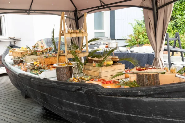 Luxury catering by the pool, food bloggers event, banquet, wedding, festive, hotel brunch buffet arrangement with clean simple design, decorations, boat filled with ice. Modern design and decorations