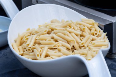 Şef makarna, haşlama ve pişirme hazırlıyor. Yemek şirketi resepsiyon sırasında canlı yemek yapıyor.