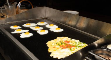 Bir otel ya da restoran ortamında yumurta ve omlet istasyonu, yemek servisi ya da açık büfe kahvaltısı ya da mutfak.