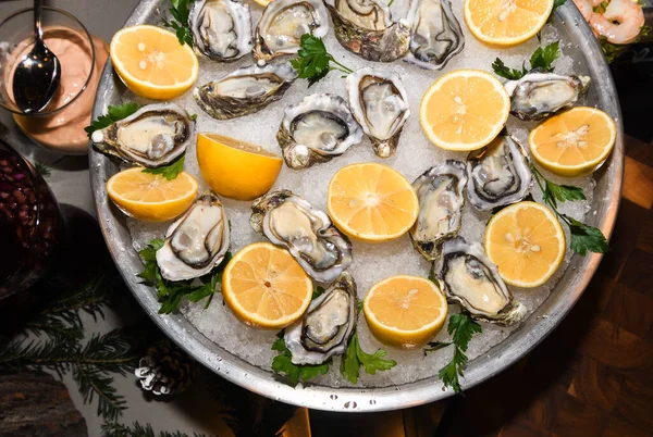 Fresh oysters with lemon on ice during hotel brunch buffet outside outdoor in the garden by the pool. Fresh Food Buffet Brunch Catering Dining Eating Party Sharing Concept