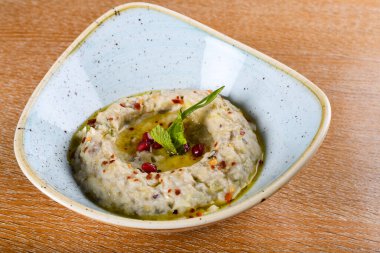 Baba ghanoush, also spelled baba ganoush or baba ghanouj, is a Levantine appetizer of mashed cooked eggplant mixed with tahini, olive oil, possibly lemon juice, and various seasonings. clipart