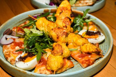 Roka salatalı tavuk tandır, sumac baharatlı yumurta, pitta ekmeği. Restoranda servis edilen Asya yemekleri.