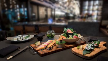 Arka planda bulanık bir restoranda sushi sashimi nigiri spesiyalitesi seçimi, en üstte bedava fotokopi alanı