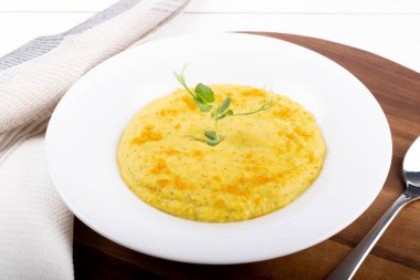 Beyaz bir kasede karışık sebze kremalı çorba, beyaz arka planda izole edilmiş, ahşap mutfak kesme tahtası, peçete, kızarmış ekmekle servis ediliyor. Yukarıdaki biçimi göster ve kapat, temiz ve basit arkaplan