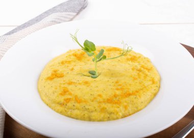 Beyaz bir kasede karışık sebze kremalı çorba, beyaz arka planda izole edilmiş, ahşap mutfak kesme tahtası, peçete, kızarmış ekmekle servis ediliyor. Yukarıdaki biçimi göster ve kapat, temiz ve basit arkaplan