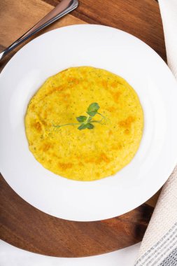 Beyaz bir kasede karışık sebze kremalı çorba, beyaz arka planda izole edilmiş, ahşap mutfak kesme tahtası, peçete, kızarmış ekmekle servis ediliyor. Yukarıdaki biçimi göster ve kapat, temiz ve basit arkaplan