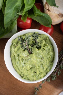 Tahtada izole edilmiş yeşil bezelyelerden yapılmış glütensiz pişmiş makarna. Fesleğen, domates, avokado ve kişniş. Yukarıdan ateş edilmiş ve yakın plan. yemek arkaplanı İtalyan makarna