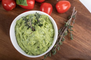 Tahtada izole edilmiş yeşil bezelyelerden yapılmış glütensiz pişmiş makarna. Fesleğen, domates, avokado ve kişniş. Yukarıdan ateş edilmiş ve yakın plan. yemek arkaplanı İtalyan makarna