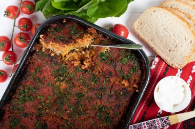 Lahana, domates ezmesi ve kıyma, pirinç ve dereotu, kırmızı peçete, salata ve domates, ekmek ve baharattan yapılan geleneksel Romen yemeği