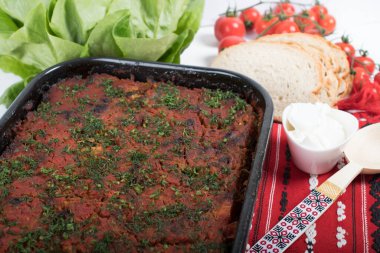 Lahana, domates ezmesi ve kıyma, pirinç ve dereotu, kırmızı peçete, salata ve domates, ekmek ve baharattan yapılan geleneksel Romen yemeği