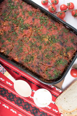 Lahana, domates ezmesi ve kıyma, pirinç ve dereotu, kırmızı peçete, salata ve domates, ekmek ve baharattan yapılan geleneksel Romen yemeği