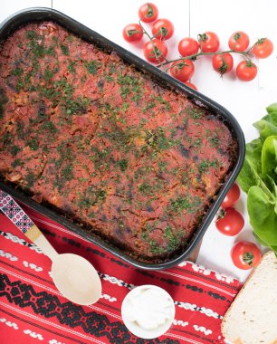 Lahana, domates ezmesi ve kıyma, pirinç ve dereotu, kırmızı peçete, salata ve domates, ekmek ve baharattan yapılan geleneksel Romen yemeği