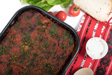 Lahana, domates ezmesi ve kıyma, pirinç ve dereotu, kırmızı peçete, salata ve domates, ekmek ve baharattan yapılan geleneksel Romen yemeği