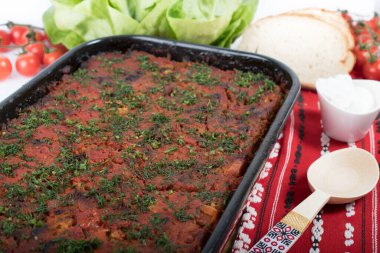 Lahana, domates ezmesi ve kıyma, pirinç ve dereotu, kırmızı peçete, salata ve domates, ekmek ve baharattan yapılan geleneksel Romen yemeği