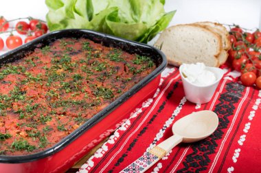 Lahana, domates ezmesi ve kıyma, pirinç ve dereotu, kırmızı peçete, salata ve domates, ekmek ve baharattan yapılan geleneksel Romen yemeği