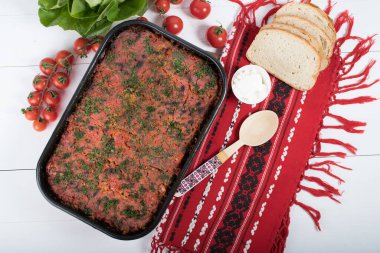 Lahana, domates ezmesi ve kıyma, pirinç ve dereotu, kırmızı peçete, salata ve domates, ekmek ve baharattan yapılan geleneksel Romen yemeği