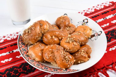 Romanya mutfağı kavramı. Ev yapımı Mucenici, sekizinci şekle bürünmüş geleneksel tatlılar, ballı ve doğranmış fındıklı çelenk..