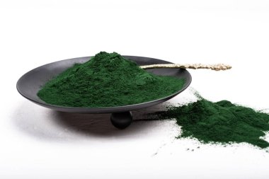 Beyaz ya da kırsal arkaplanda kurumuş organik spirulina alglerinden oluşan izole bir çorba kaşığı. Sağlıklı yaşam, detoks tarifleri, çiğ vejetaryen içeceği veya meyve suyu malzemeleri.