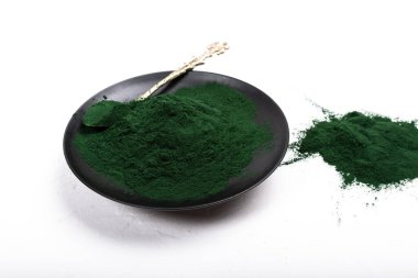 Beyaz ya da kırsal arkaplanda kurumuş organik spirulina alglerinden oluşan izole bir çorba kaşığı. Sağlıklı yaşam, detoks tarifleri, çiğ vejetaryen içeceği veya meyve suyu malzemeleri.