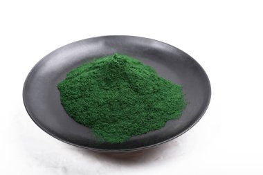 Beyaz ya da kırsal arkaplanda kurumuş organik spirulina alglerinden oluşan izole bir çorba kaşığı. Sağlıklı yaşam, detoks tarifleri, çiğ vejetaryen içeceği veya meyve suyu malzemeleri.