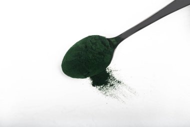 Beyaz ya da kırsal arkaplanda kurumuş organik spirulina alglerinden oluşan izole bir çorba kaşığı. Sağlıklı yaşam, detoks tarifleri, çiğ vejetaryen içeceği veya meyve suyu malzemeleri.
