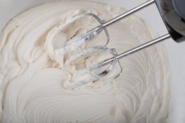 Krem şanti ve mikser yukarıdan tatlı manzarası hazırlıyor.