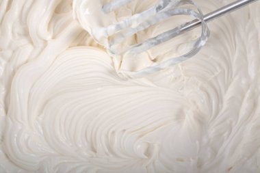 Krem şanti ve mikser yukarıdan tatlı manzarası hazırlıyor.