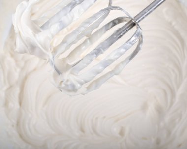 Krem şanti ve mikser yukarıdan tatlı manzarası hazırlıyor.