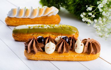 Krema ve sosla doldurulmuş choux hamur hamurundan yapılmış ekler. Zarif, lüks, pahalı şekerleme konsepti. Taze Yemek Büfesi Yemek Yemeği Paylaşım Partisi Konsepti