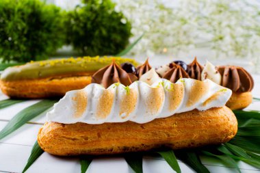 Krema ve sosla doldurulmuş choux hamur hamurundan yapılmış ekler. Zarif, lüks, pahalı şekerleme konsepti. Taze Yemek Büfesi Yemek Yemeği Paylaşım Partisi Konsepti