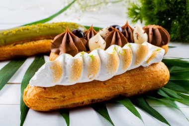 Krema ve sosla doldurulmuş choux hamur hamurundan yapılmış ekler. Zarif, lüks, pahalı şekerleme konsepti. Taze Yemek Büfesi Yemek Yemeği Paylaşım Partisi Konsepti