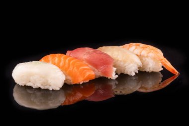 Basit suşi nigiri maki seti siyah arka planda izole edildi. Geleneksel Japon yemeklerinin çeşitli çeşitleri. Fotokopi alanlı taze deniz ürünleri Asya mutfağı spesiyali. Yemek çubukları, hiç kimse, suşi tabağı.
