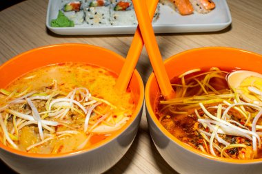 Asya erişte çorbası, tavuklu ramen, tofu, sebze ve siyah kasede yumurta. Geçmişi sil. Üst görünüm.