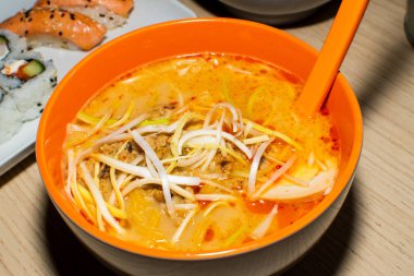 Asya erişte çorbası, tavuklu ramen, tofu, sebze ve siyah kasede yumurta. Geçmişi sil. Üst görünüm.