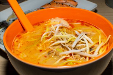 Asya erişte çorbası, tavuklu ramen, tofu, sebze ve siyah kasede yumurta. Geçmişi sil. Üst görünüm.