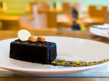 Tatlı seçimi: amandine, çikolatalı ve çilekli krema, karamel kek, restoran ortamında, bulanık arkaplan