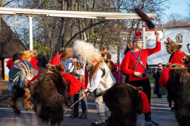 Bükreş, Romanya, 25 Aralık 2019: Balkanlar 'da Noel geleneği festivali, Romen dansçılar ve geleneksel çingene kıyafetleri içindeki aktörler, dans eden ayı gösterisi 