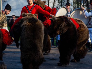 Bükreş, Romanya, 25 Aralık 2019: Balkanlar 'da Noel geleneği festivali, Romen dansçılar ve geleneksel çingene kıyafetleri içindeki aktörler, dans eden ayı gösterisi 