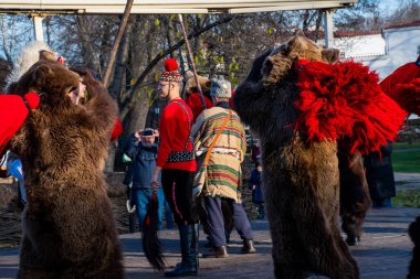 Bükreş, Romanya, 25 Aralık 2019: Balkanlar 'da Noel geleneği festivali, Romen dansçılar ve geleneksel çingene kıyafetleri içindeki aktörler, dans eden ayı gösterisi 