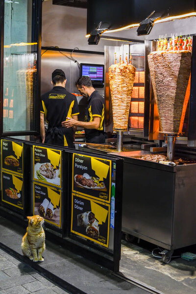 Стамбул, Турция, 20.12.2019: Человек режет шаурма кебаб на шампуре
