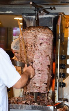 İstanbul, Türkiye, 20.12.2019: Şişe üzerinde shawarma kebabı kesen adam