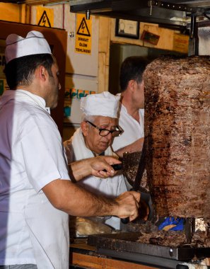 İstanbul, Türkiye, 20.12.2019: Şişe üzerinde shawarma kebabı kesen adam