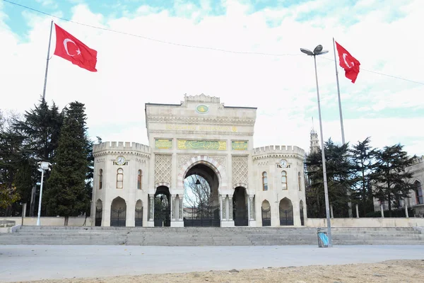 İSTANBUL, Turkey - 20.12.2019. Beyazit Meydanı 'ndaki İstanbul Üniversitesi' nin ana giriş kapısı Türk bayraklarıyla. Beyazit meydanında uçan güvercinler.