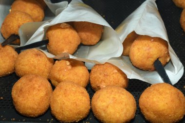 Arancini (bol etli kızarmış pirinç topları) İtalya 'daki markette tipik Sicilya sokak yemekleri. Sokak yemeklerinde satılacak bir sürü kızarmış pirinç topları.