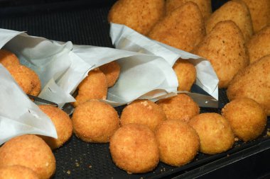 Arancini (bol etli kızarmış pirinç topları) İtalya 'daki markette tipik Sicilya sokak yemekleri. Sokak yemeklerinde satılacak bir sürü kızarmış pirinç topları.