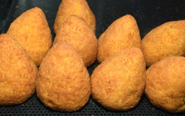 Arancini (bol etli kızarmış pirinç topları) İtalya 'daki markette tipik Sicilya sokak yemekleri. Sokak yemeklerinde satılacak bir sürü kızarmış pirinç topları.