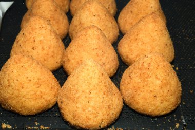 Arancini (bol etli kızarmış pirinç topları) İtalya 'daki markette tipik Sicilya sokak yemekleri. Sokak yemeklerinde satılacak bir sürü kızarmış pirinç topları.