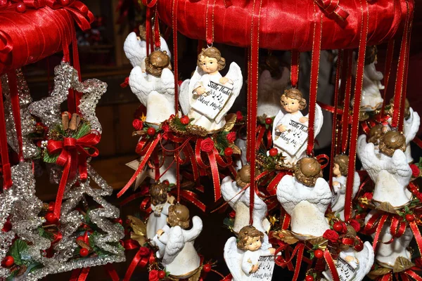 圣诞树装饰品装饰红丝带和可爱的小天使挂在树上出售 — 图库照片
