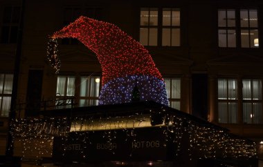 Noel ağacı, gece boyunca, ışıklar ve ortasında kırmızı kurdele ile süslenmiş. Tepede parlayan yıldız